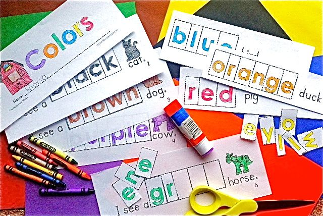 pages of the color word book are completed with color words glued in order to complete each sentence and pictures colored with crayon. Crayons, a glue stick and scissors lay on top of them