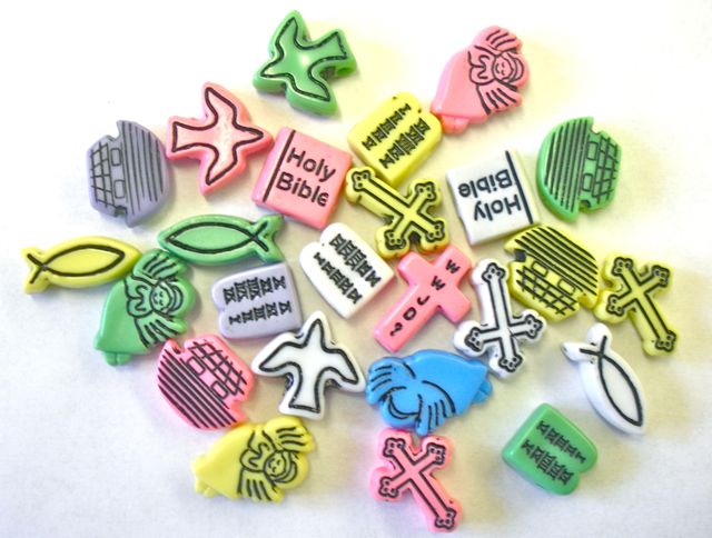 assorted plastic beads for children's rosary in the shapes of doves, crosses, christian fish, bibles, arcs, and angels