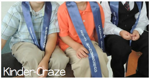 boys sitting at kindergarten graduation and wearing custom sashes instead of a cap and gown