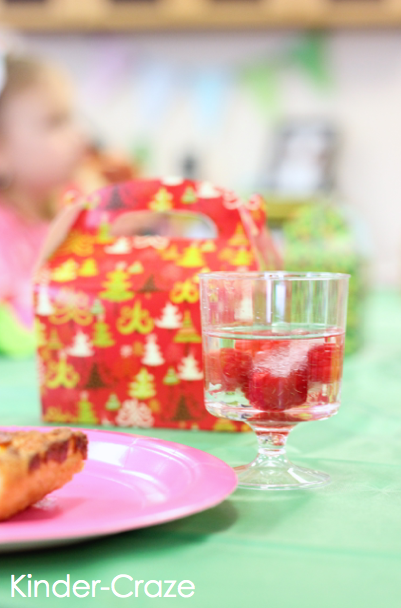 student table with raspberry ice cube water and piece of pizza at classroom holiday party