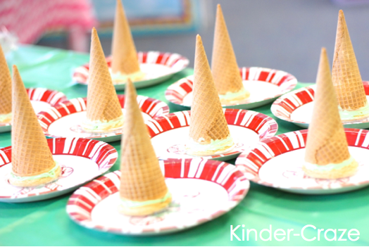 student's sugar cookies topped with ice cream cones on holiday paper plates sit on table before they are frosted