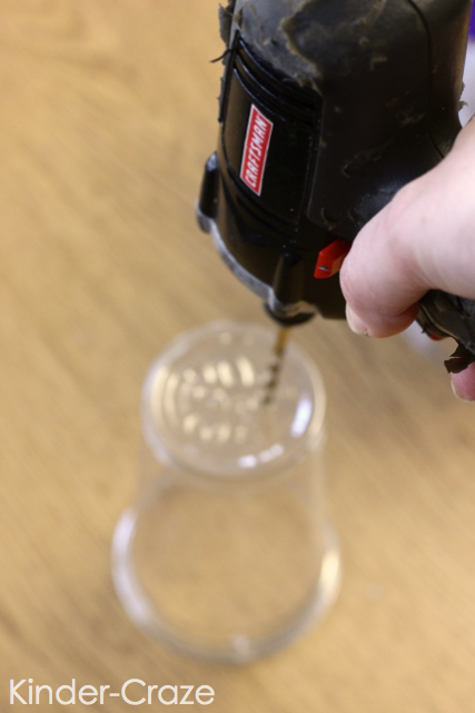 black power drill drilling hole into bottom of clear plastic cup