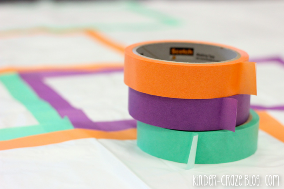 rolls of orange, purple and green tape sitting on top of white mat with colorful hopscotch squares