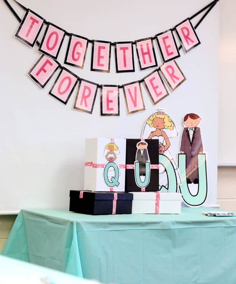 kindergarten Q and U wedding celebration decorations displayed on a table with a banner that says "together forever"