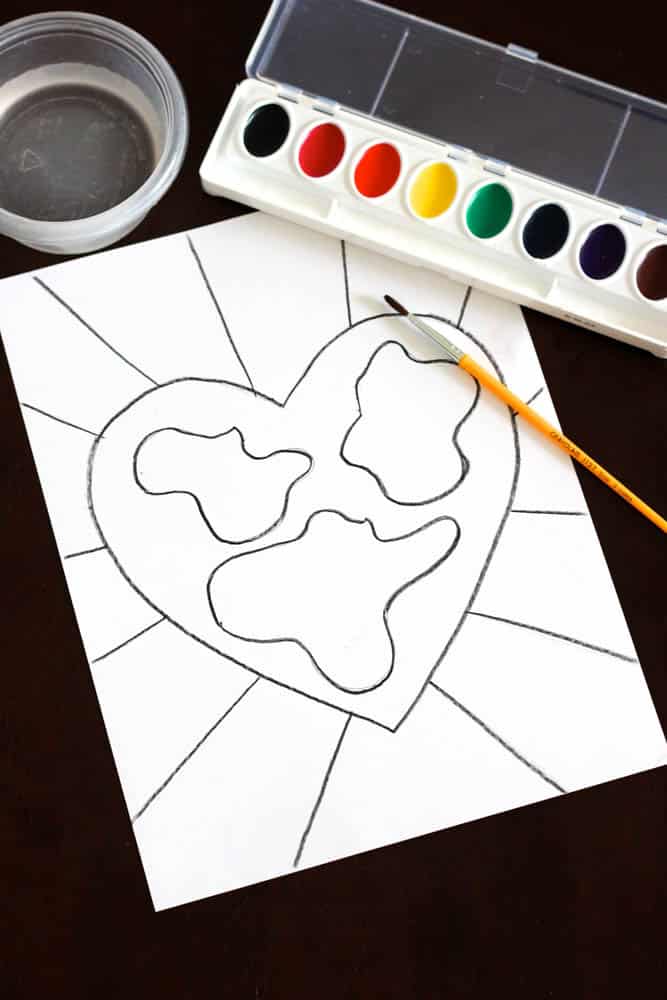 heart-shaped earth drawing for kids project for kids on white paper traced with black crayon that's ready to paint
