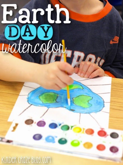 child painting earth shaped like a heart with the text "earth day watercolor"