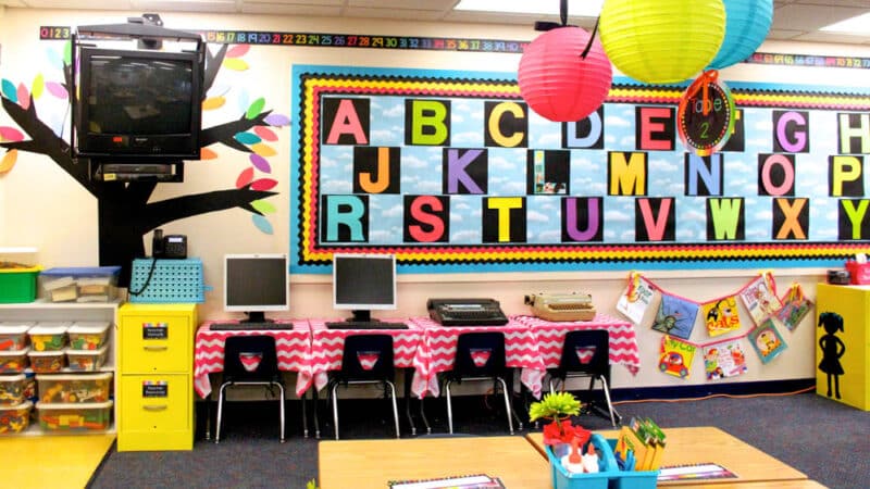 kindergarten classroom with computers, typewriters and brighly colored alphabet word wall