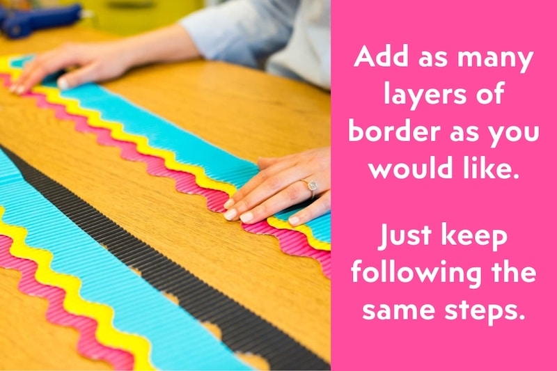 placing teal, yellow, and pink bulletin board layers together for a classroom bulletin board