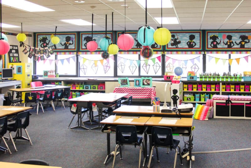 brightly colored kindergarten classroom with colorful lanterns hanging from the ceiling, rainbow colored book bins in the classroom library lots of fun decorations