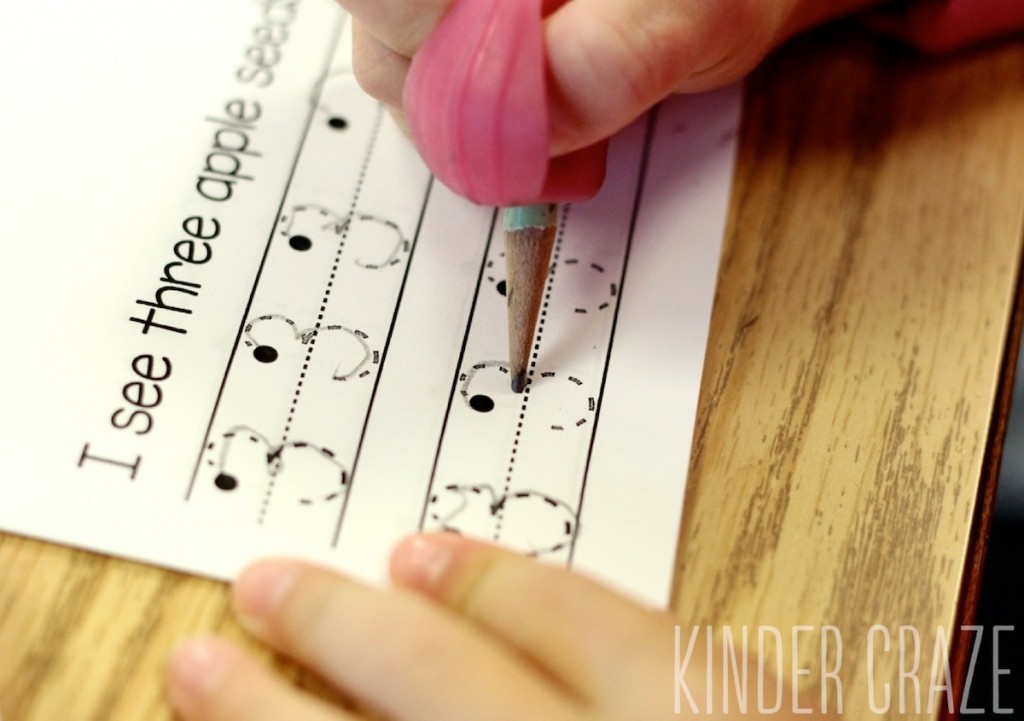 kindergarten student writes number three in apple handwriting book