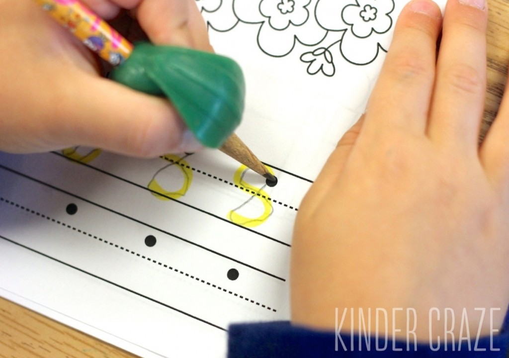 kindergarten student uses pencil to trace number eight in fall number writing book