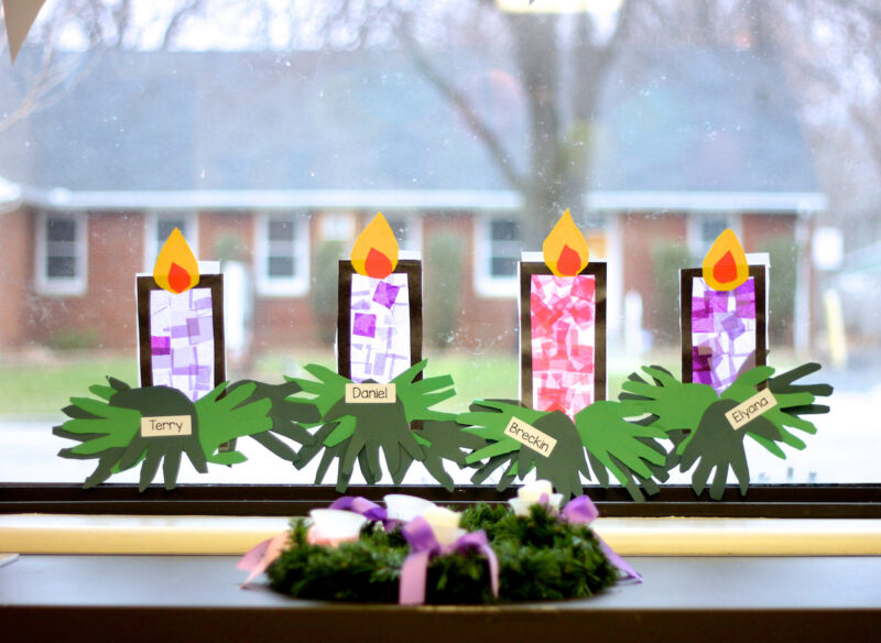 pruple and pink stained glass advent candle window crafts hang in classroom window behind advent wreath