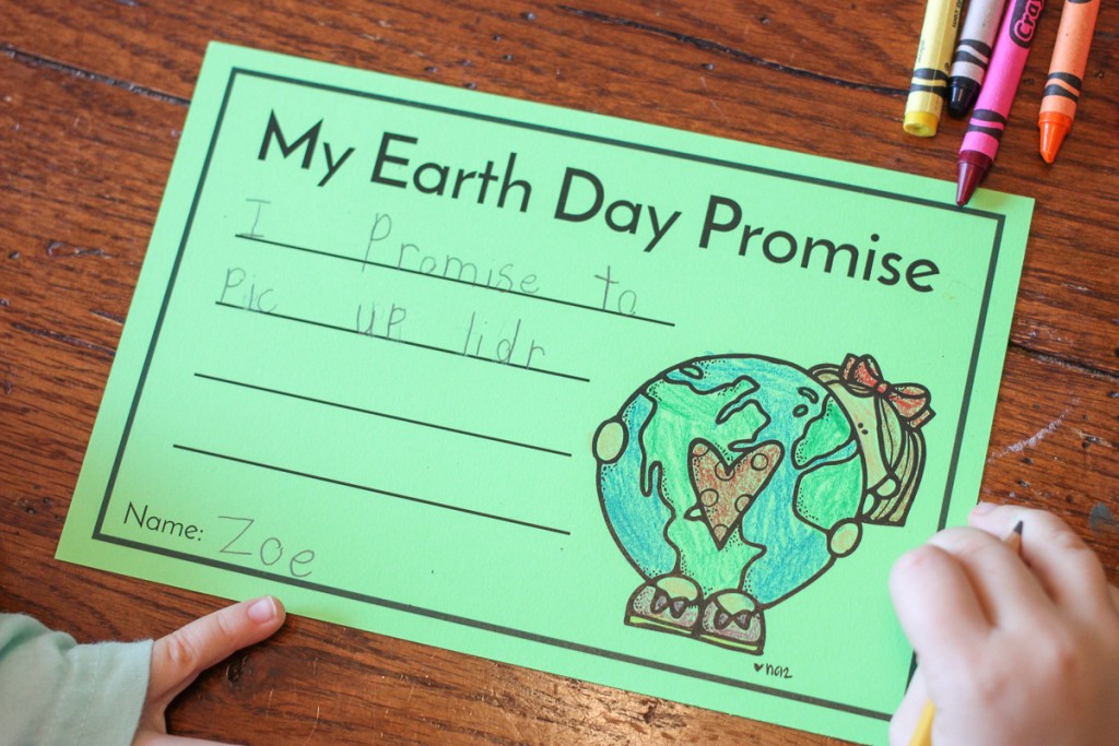 kindergarten student writing earth day promise that says "I promise to pick up litter"