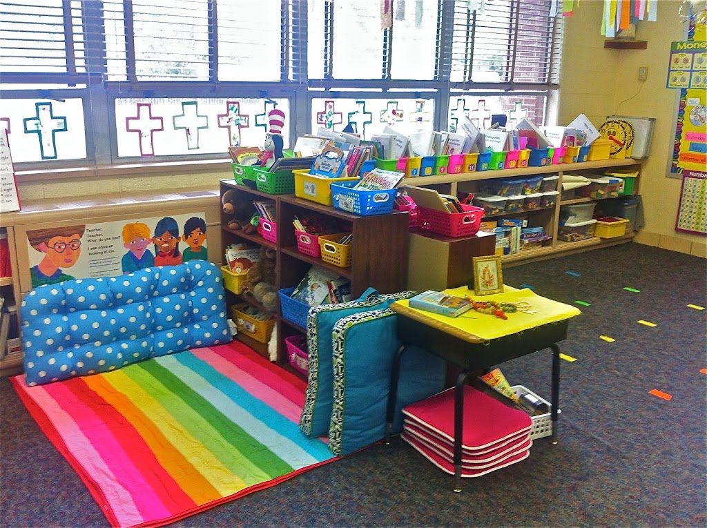 library corner with books in bins on shelves in a kindergarten classroom with cushions as alternate seating