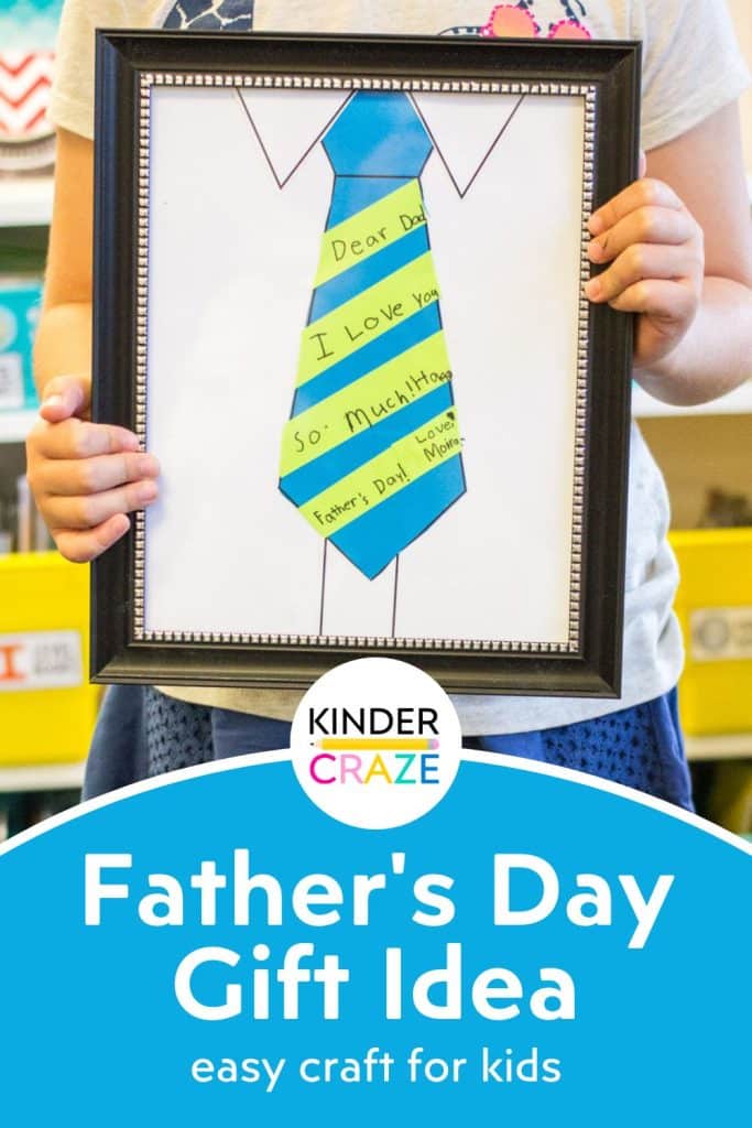 child holding a framed necktie paper craft with a personalized note to dad written on the tie - the words "father's day gift idea" appear along the bottom of the image