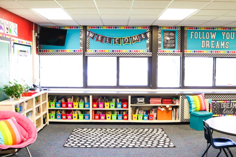 first grade classroom library area with brightly colored bins on shelves for classroom makeover