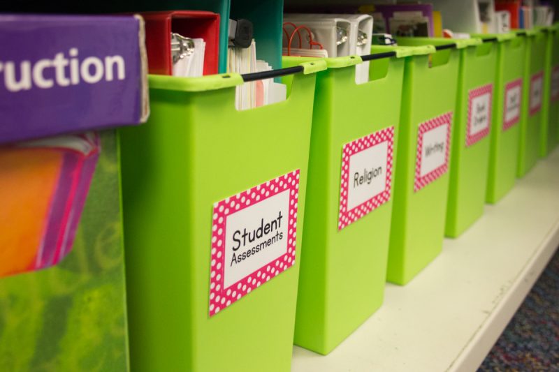 green magazine bins with labels in a first grade classroom library