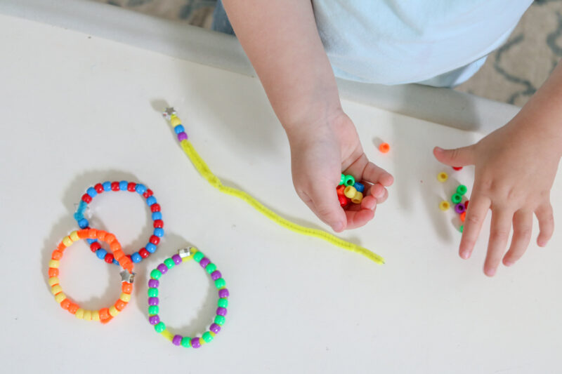 Looking for easy toddler activities? Use pony beads and pipe cleaners to create a simple bracelet. It's a great way to develop fine motor skills and work on pincer grasp. Make the activity even more meaningful by encouraging your child to make patterns. Pattern bracelets are a great mess-free activity for 3 year old and 4 year old children to work on at-home or in a preschool classroom. 
